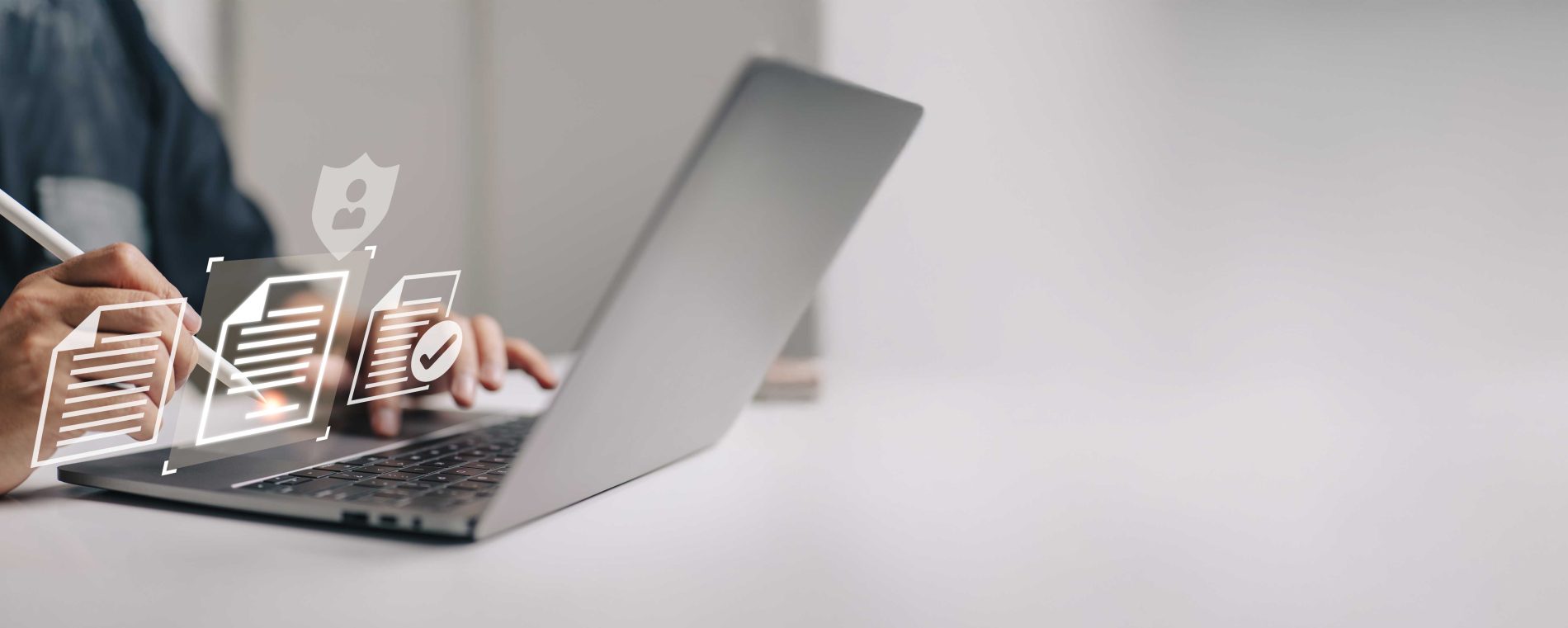 A person signing digital documents on a laptop, representing secure IP agreement services